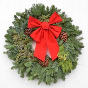 christmas wreath with green bough, yellow cedar, blue juniper berries, three pinecones and red bow